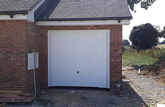 A Garador Carlton style up and over garage door in white with a white steel frame. Fitted in Basingstoke, Hampshire.
