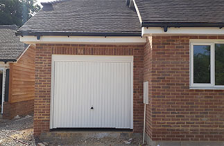 A Garador Carlton style up and over garage door in white with a white steel frame. Fitted in Basingstoke, Hampshire.