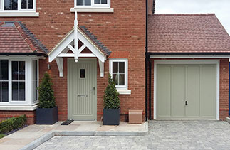 A Garador Grantham style timber up and over garage door with a white steel frame and a white chassis. Supplied in a Farrow and Ball colour match to French Grey. Fitted in Farnham, Surrey.