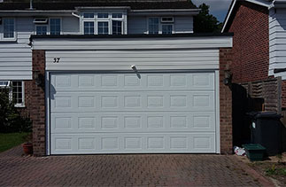 A Garador Georgian Premium Sectional Garage Door with NO branding badge with matching side cover profiles and fitted with a electronic operator. Fitted in Hartney Winteny, Hampshire.