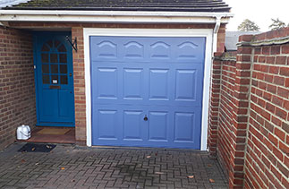 A Garador steel range Cathedral style up and over garage door in Pigeon Blue with a White steel frame. Fitted in Camberley, Surrey.