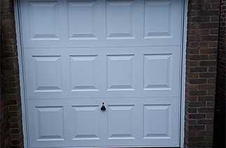 A Garador white steel up and over garage door in the Georgian style with a White steel frame and additional locking. Garage door fitted in Camberley, Surrey.