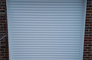 A Sws Seceuroglide Excel white insulated roller shutter garage door. Fitted in Guildford, Surrey.