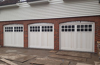 Three bespoke Woodrite Cedar wood timber up and over garage doors. Primed white for on site finishing. Fitted in Beaconsfield. Buckinghamshire.