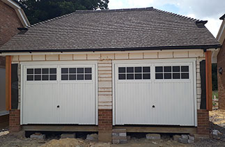 Two Garador Salisbury style up and over garage doors in white with white steel frame. Doors fitted in Basingstoke, Hampshire.
