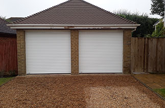 Two Sws Seceuroglide Excel white roller shutter garage doors. Fitted in Bisley, Surrey.