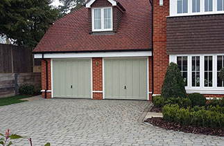 Two timber Churchill style up and over garage doors fully finished in a colour match to Farrow & Ball French Grey. Fitted in Hartley Wintney, Hampshire.
