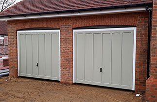 Two Woodriet timber Church hill style up and over garage doors in French Grey. With White steel frames. Fitted on a on-going site in Hartley Wintney. Hampshire.