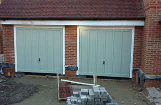 Two Woodrite timber Churchill style up and over garage doors fully finished in a colour match to Farrow & Ball French Grey. Fitted to plot 3 in Hartley Wintney, Hampshire.