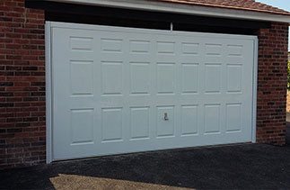 A Wessex 3 Crown Gloss white Georgian style purpose made up and over garage door with a white steel frame and a white chassis. The door is fitted with a Garador Chrome handle. Fitted in Berkshire.