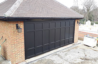A Woodrite Somerset range bespoke style up and over garage door in Burnt Oak with a matching Burnt Oak timber frame. Fitted in Esher, Surrey.